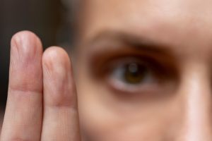 Woman going through EMDR therapy exercise with two fingers being the highlight of the image.